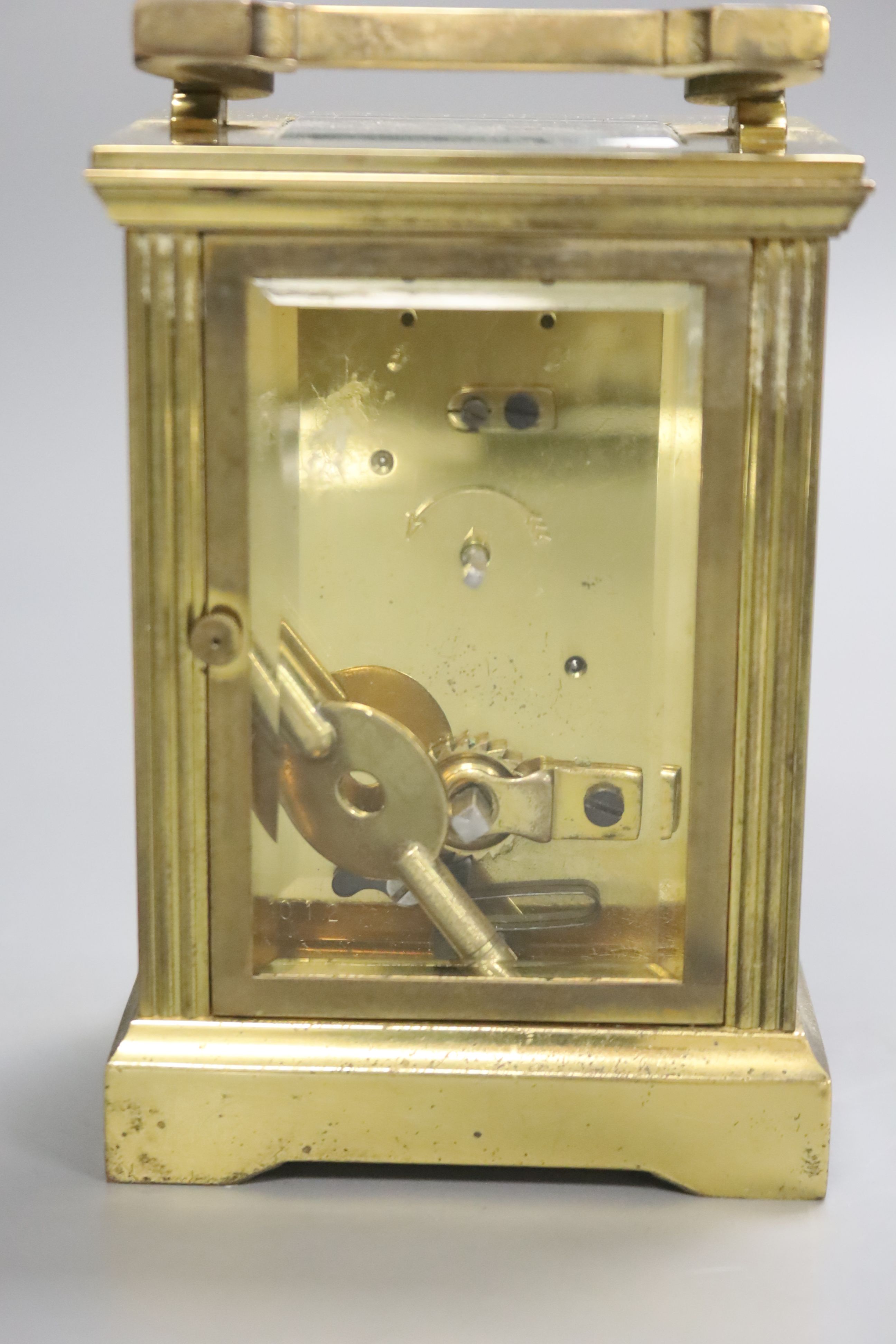 An early 20th century brass carriage timepiece, retailed by Mappin & Webb Ltd, black Roman numerals on a white dial, 8cm wide 15cm high (max.)